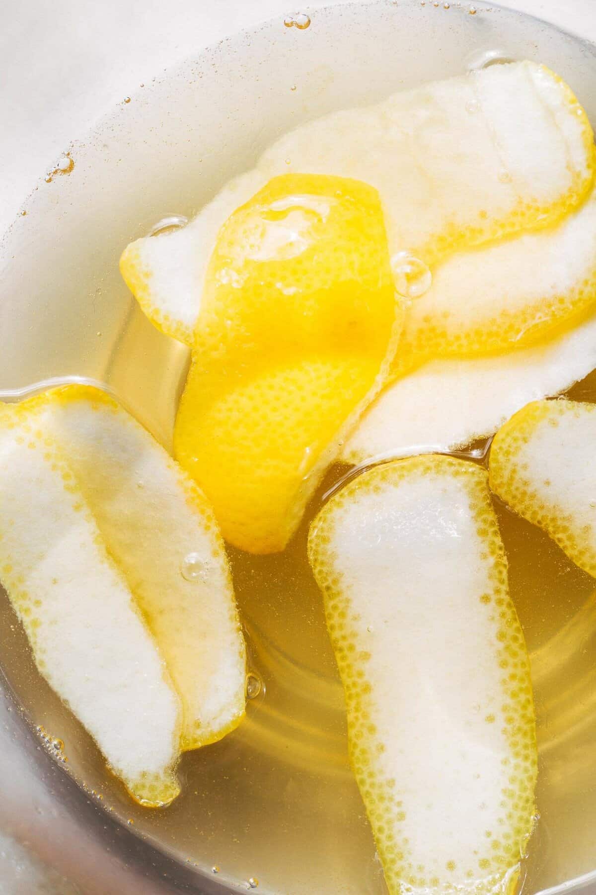 a bowl of lemon peels and lemon simple syrup