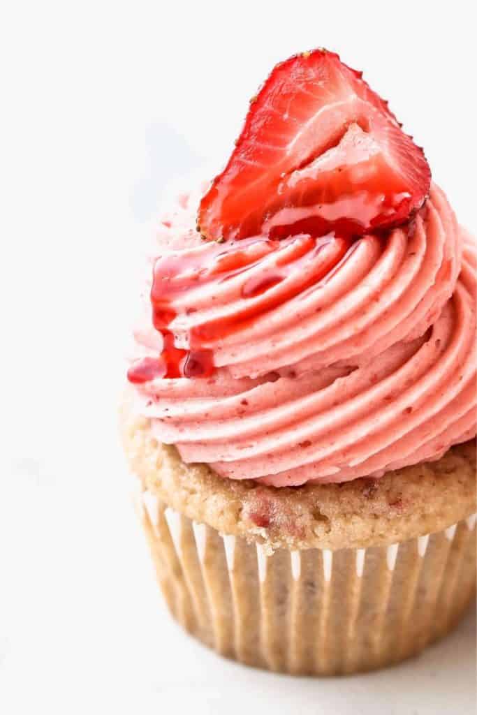 close up strawberry frosting on top of a strawberry cupcake