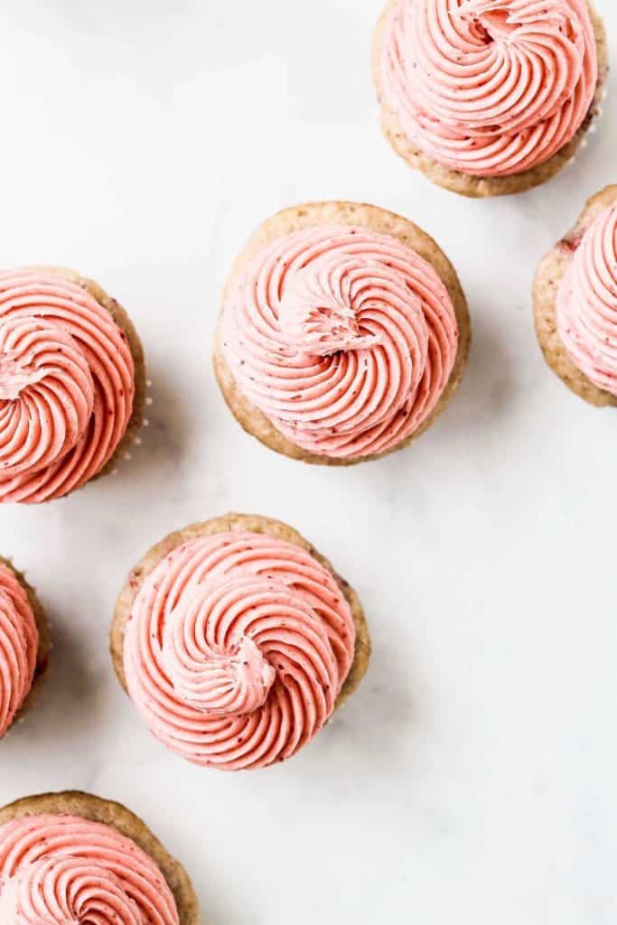 the tops of frosted strawberry cupcakes