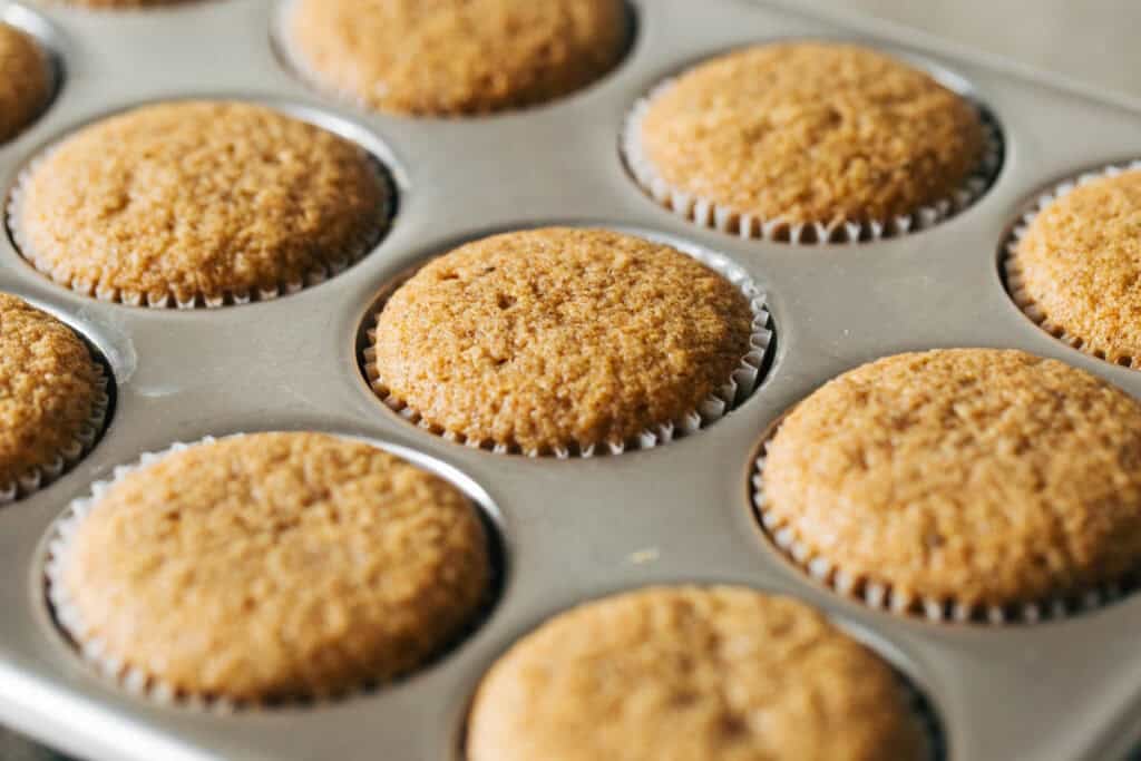 Cupcakes à la vanille et à la crème au beurre brune riche 5 Cupcakes au beurre noisette fraîchement cuits dans le plateau