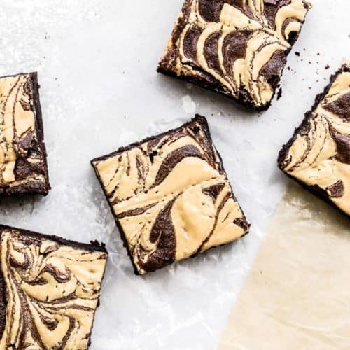 peanut butter swirl brownies scattered on parchment paper