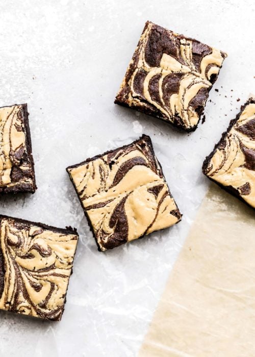 peanut butter swirl brownies scattered on parchment paper