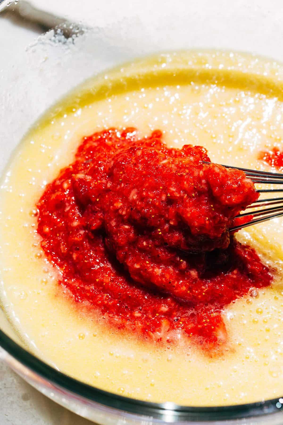 pureed strawberries in a bowl of cake batter