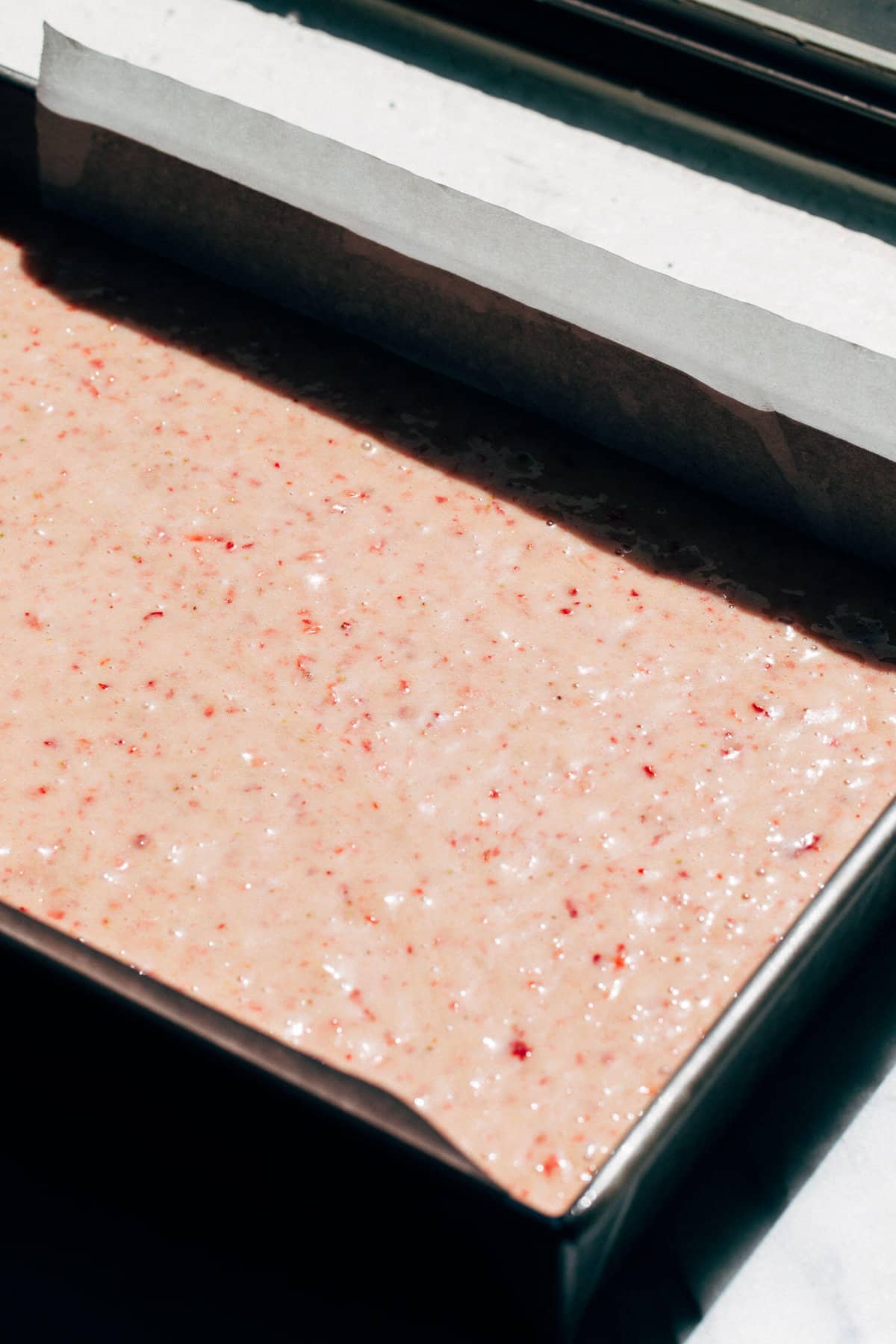 strawberry cake batter in a baking pan