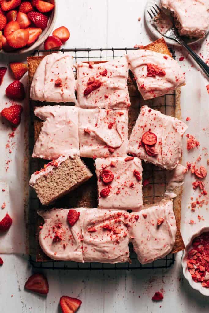 the top of a sliced strawberry sheet cake on a cooling rack