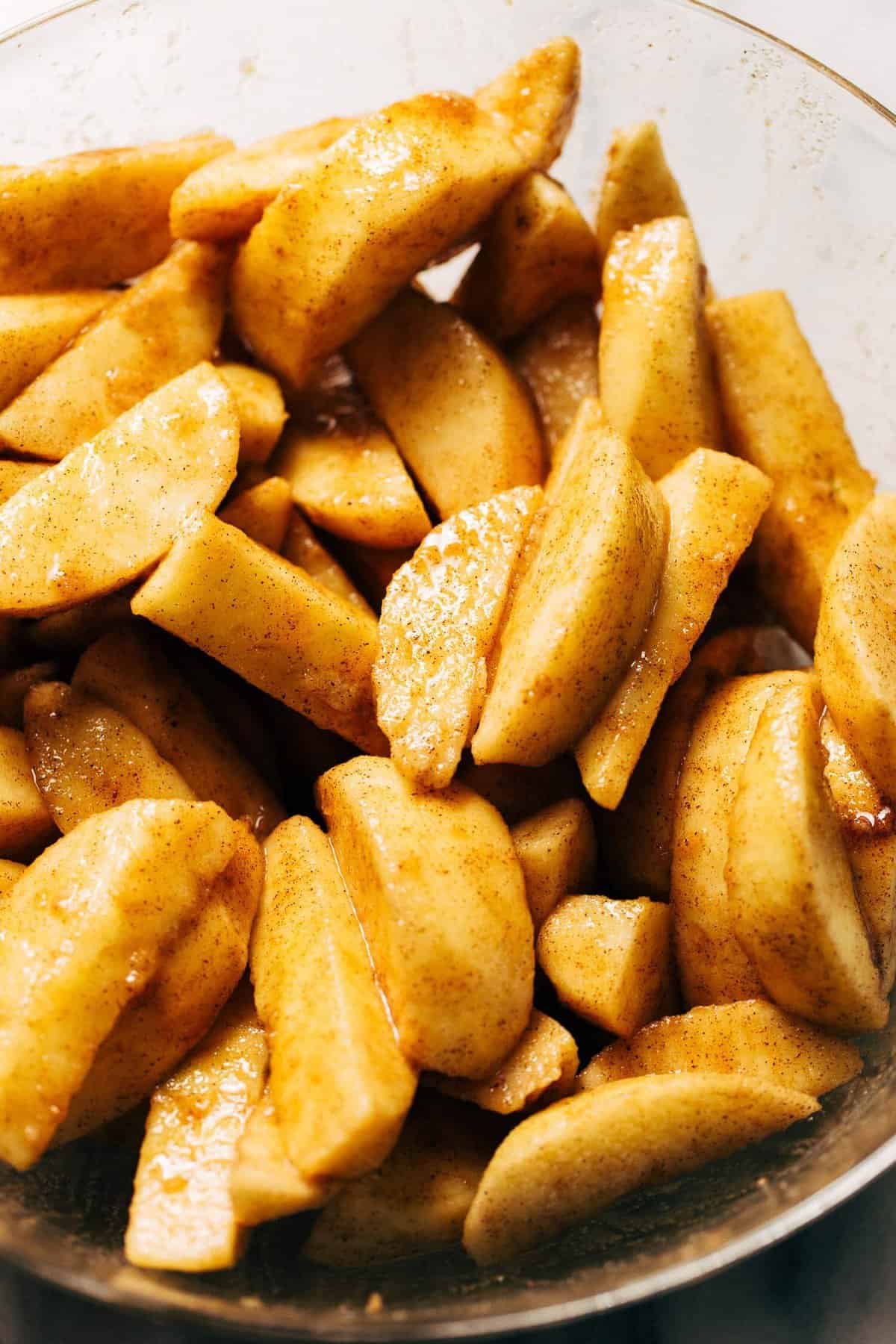 a bowl of sliced apples tossed in sugar