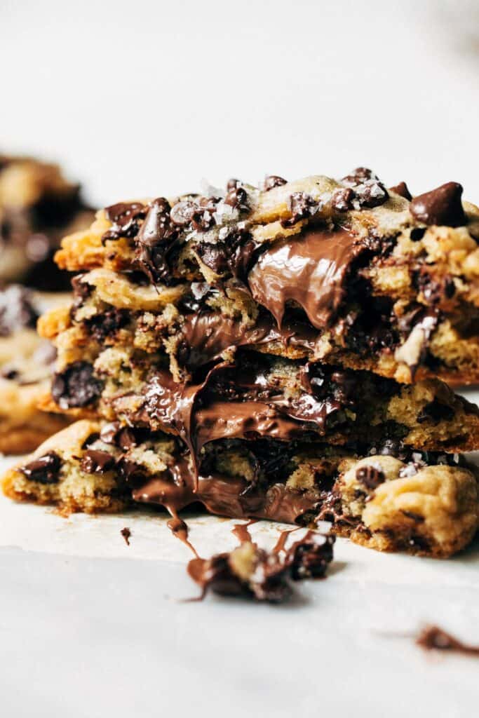 a stack of nutella stuffed chocolate chip cookies all split in half