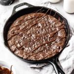 skillet brownies in a cast iron skillet with a chocolate drizzle