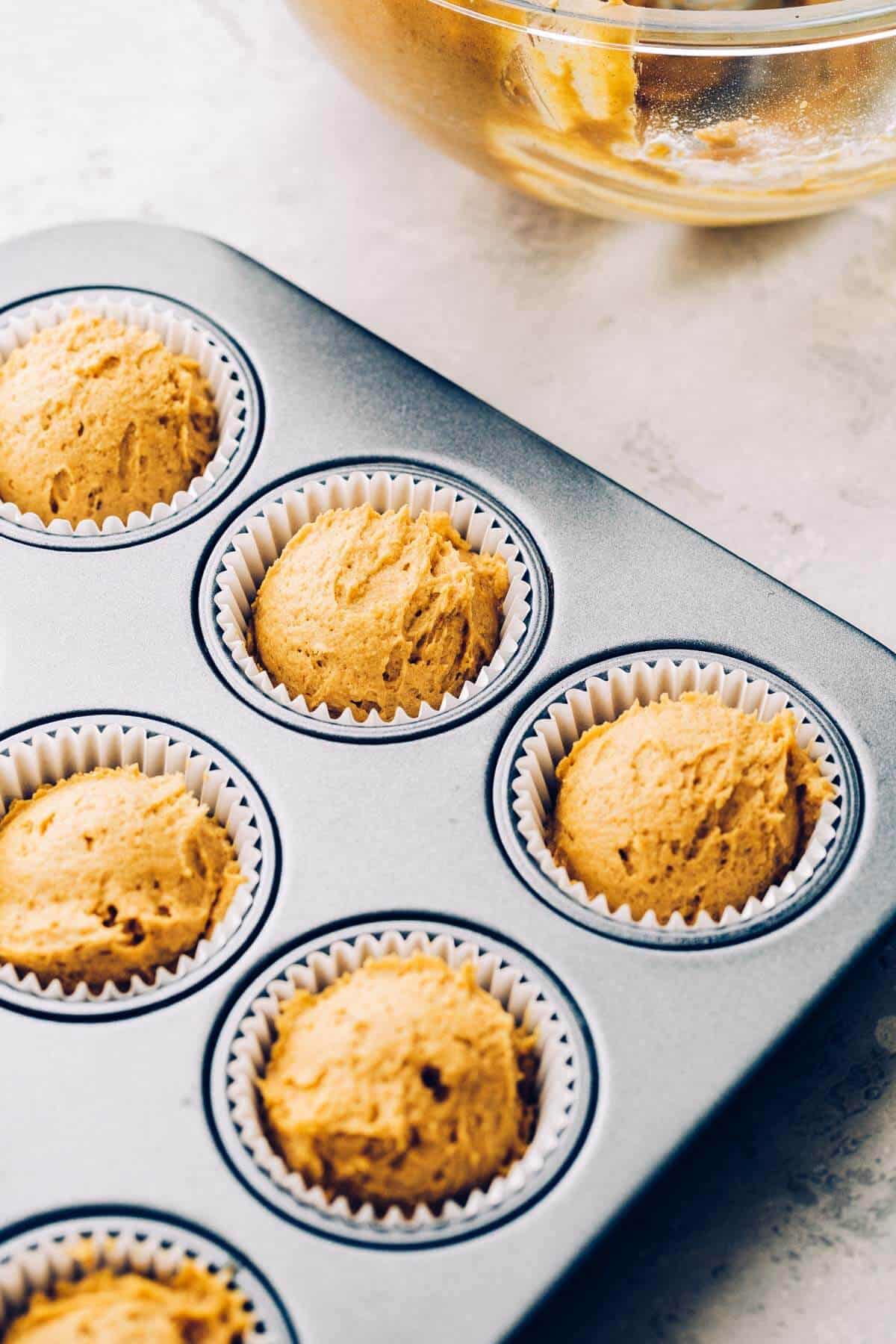 a tray of pumpkin muffins that are ready to be baked