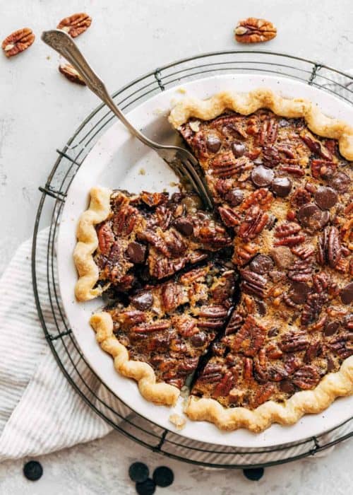 a whole and sliced chocolate bourbon pecan pie