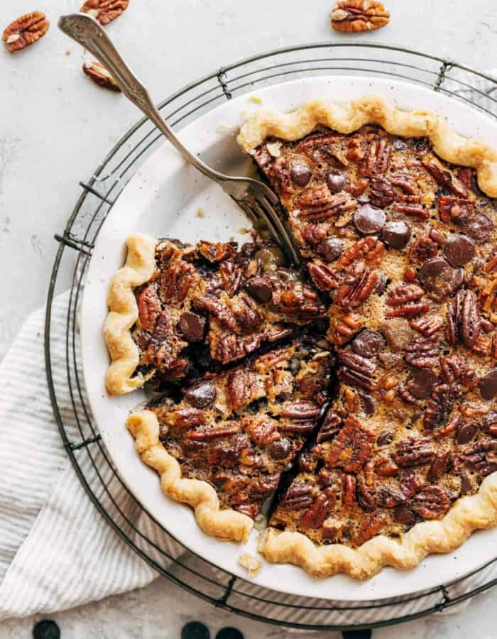 a whole and sliced chocolate bourbon pecan pie