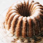 an apple cider bundt cake on a round wire cooling rack