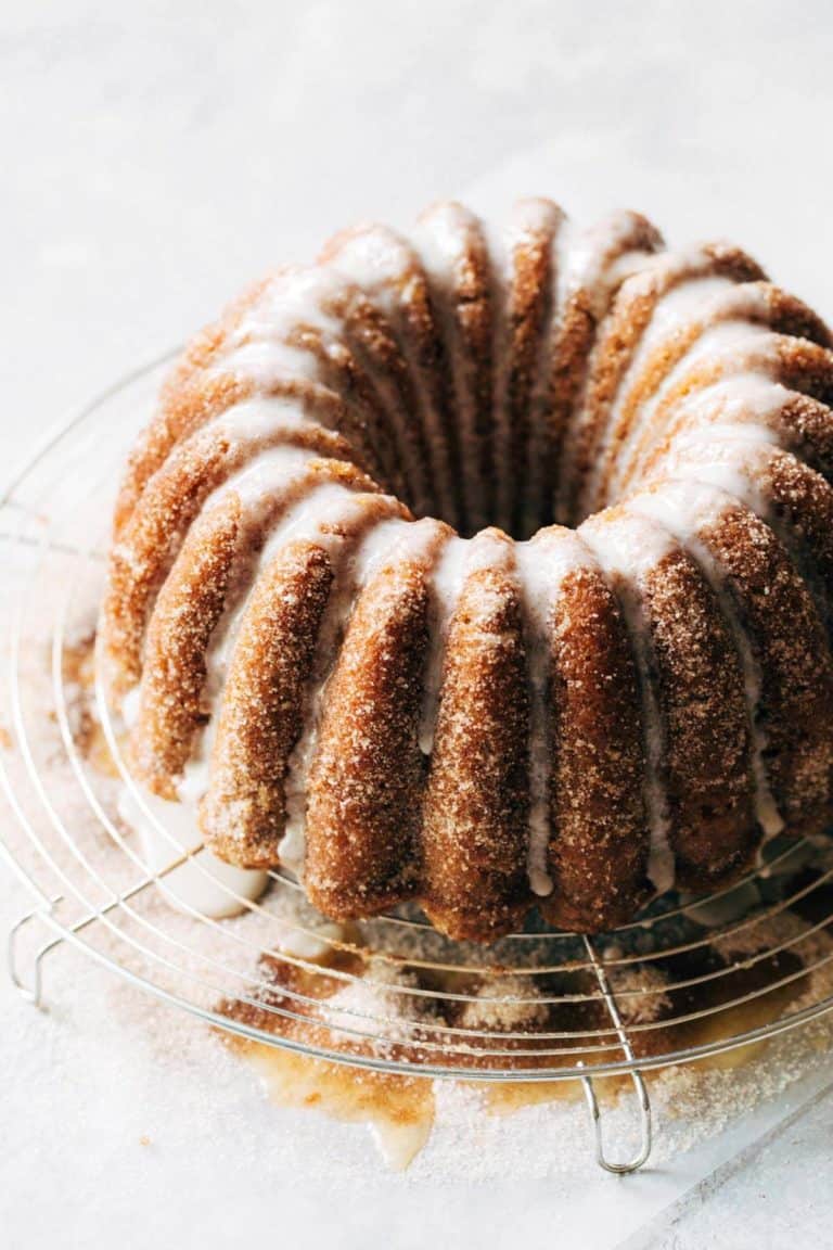 an apple cider bundt cake on a round wire cooling rack