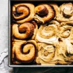 frosted gingerbread cinnamon rolls in baking pan