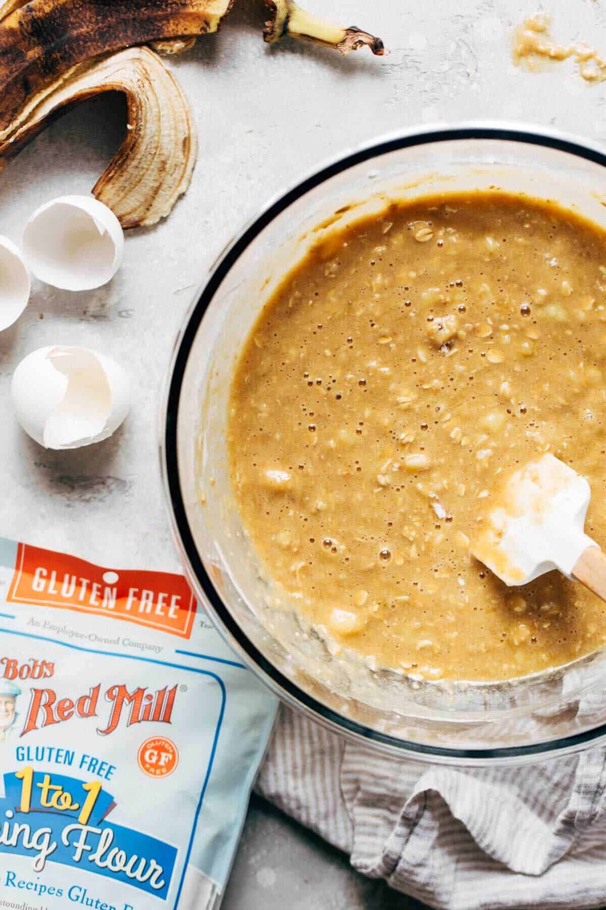 banana bread batter in a mixing bowl with a white spatula