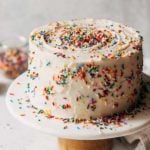 a funfetti layer cake on a cake stand