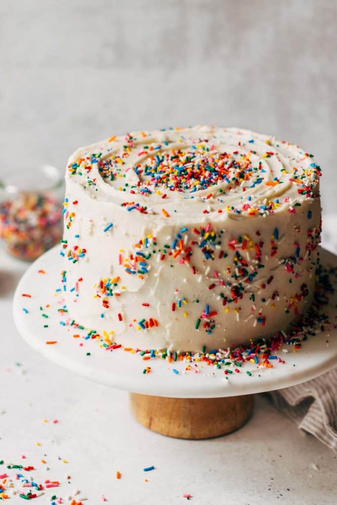 a funfetti layer cake on a cake stand