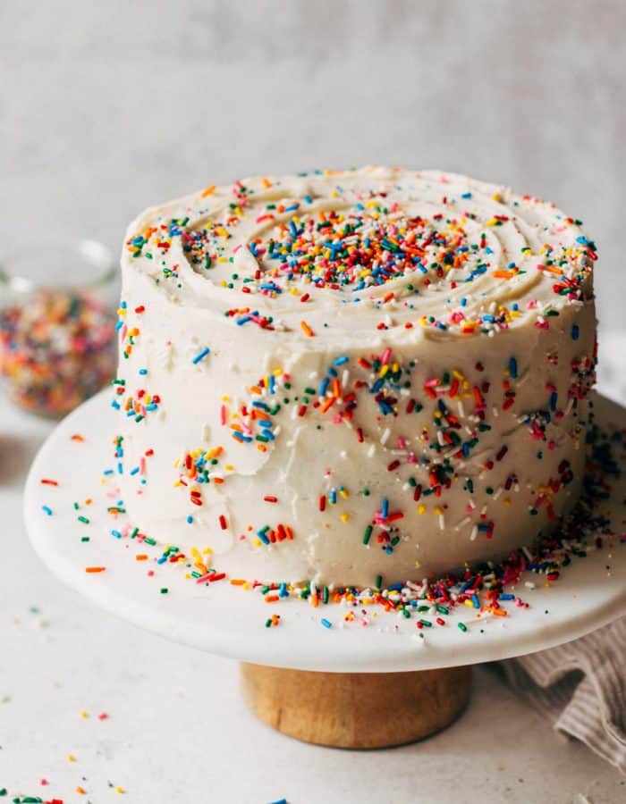 a funfetti layer cake on a cake stand