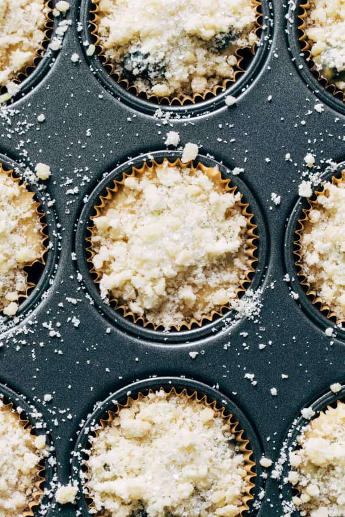 lemon blueberry muffin batter in cupcake liners with a crumb topping