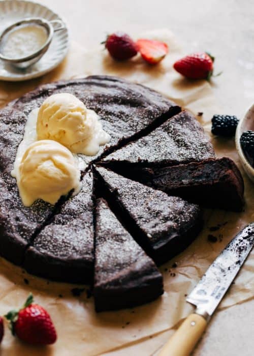 flourless chocolate cake sliced on parchment paper