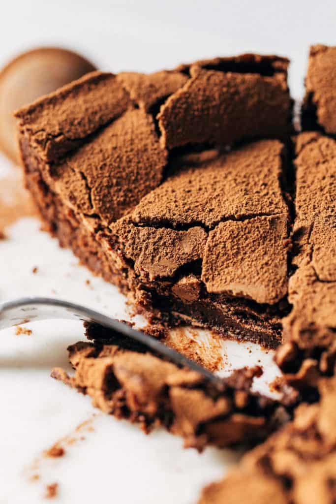 close up on a bite taken from a slice of flourless chocolate cake