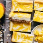 slices of mango cheesecake bars scattered in a cooling rack