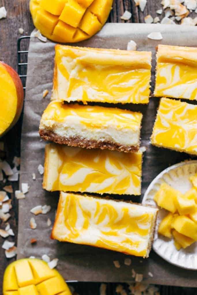slices of mango cheesecake bars scattered in a cooling rack