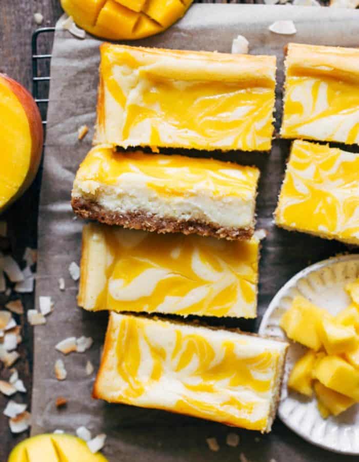 slices of mango cheesecake bars scattered in a cooling rack