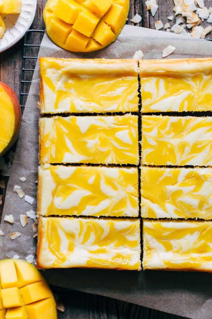 a cooling rack of slices of coconut mango cheesecake bars