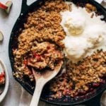 strawberry rhubarb crisp baked in a cast iron and topped with ice cream