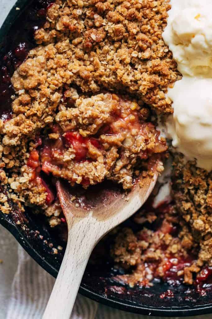 close up on a spoon full of strawberry rhubarb crisp