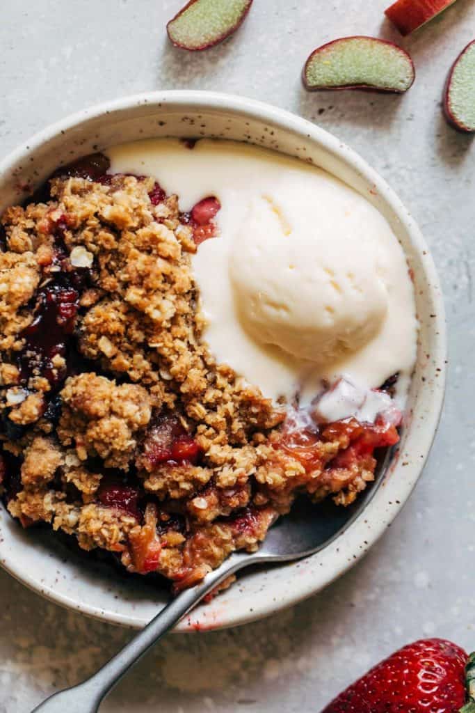 a plate of strawberry rhubarb crisp and ice cream