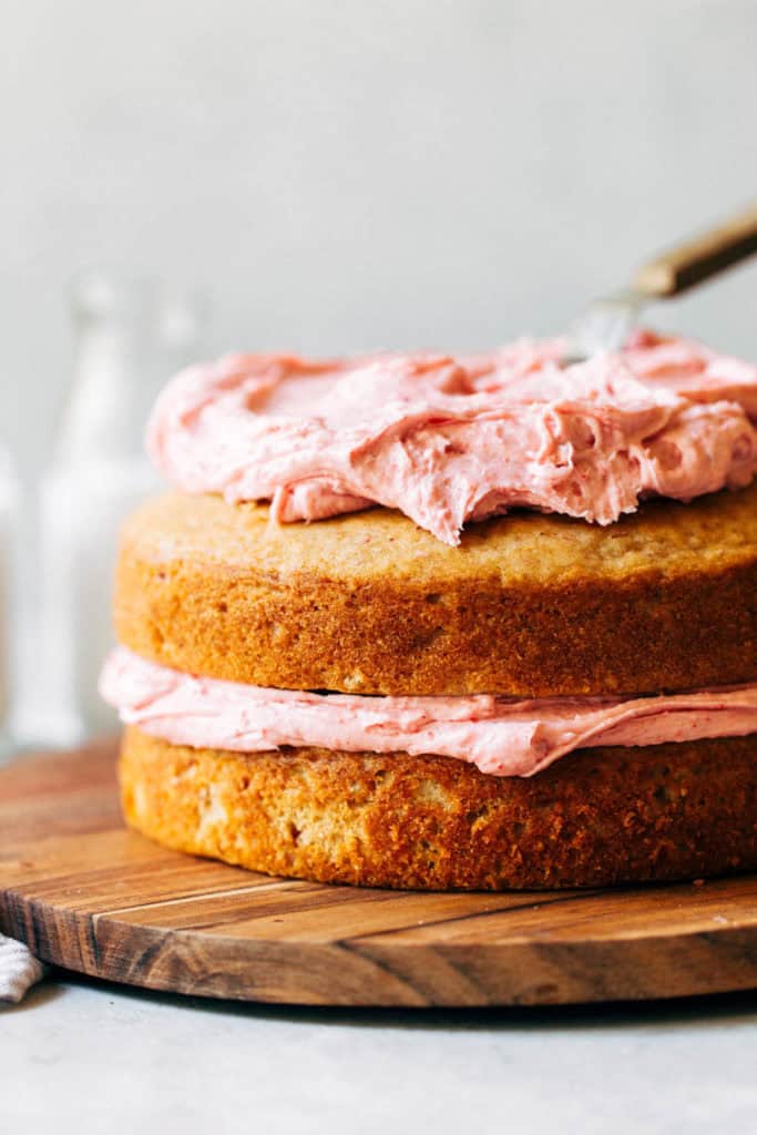 two layers of cake with strawberry frosting between each