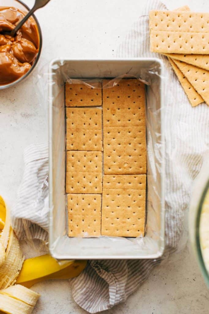 a layer of graham crackers in a the bottom of a loaf pan