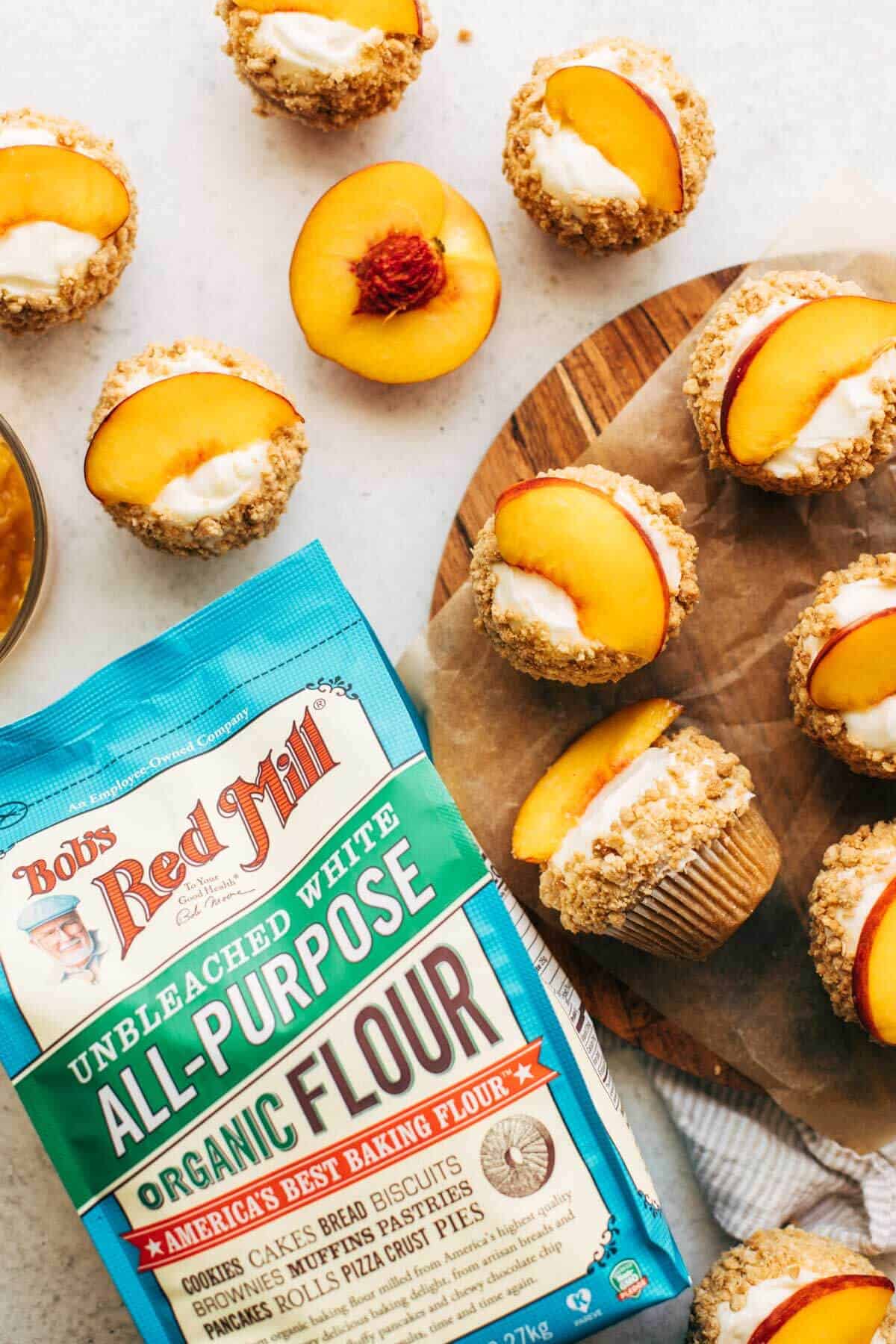 peach cupcakes scattered around a bag of flour