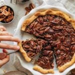 lifting a slice of pecan pie out of the pie dish