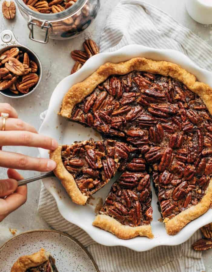 lifting a slice of pecan pie out of the pie dish