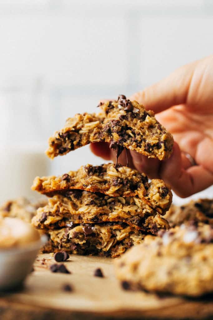 lifting a cookie from a stack of peanut butter oatmeal cookies