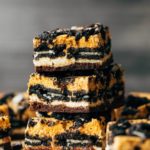 three pumpkin oreo cheesecake bars stacked on top of each other
