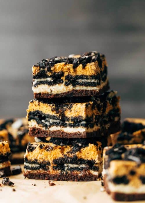 three pumpkin oreo cheesecake bars stacked on top of each other
