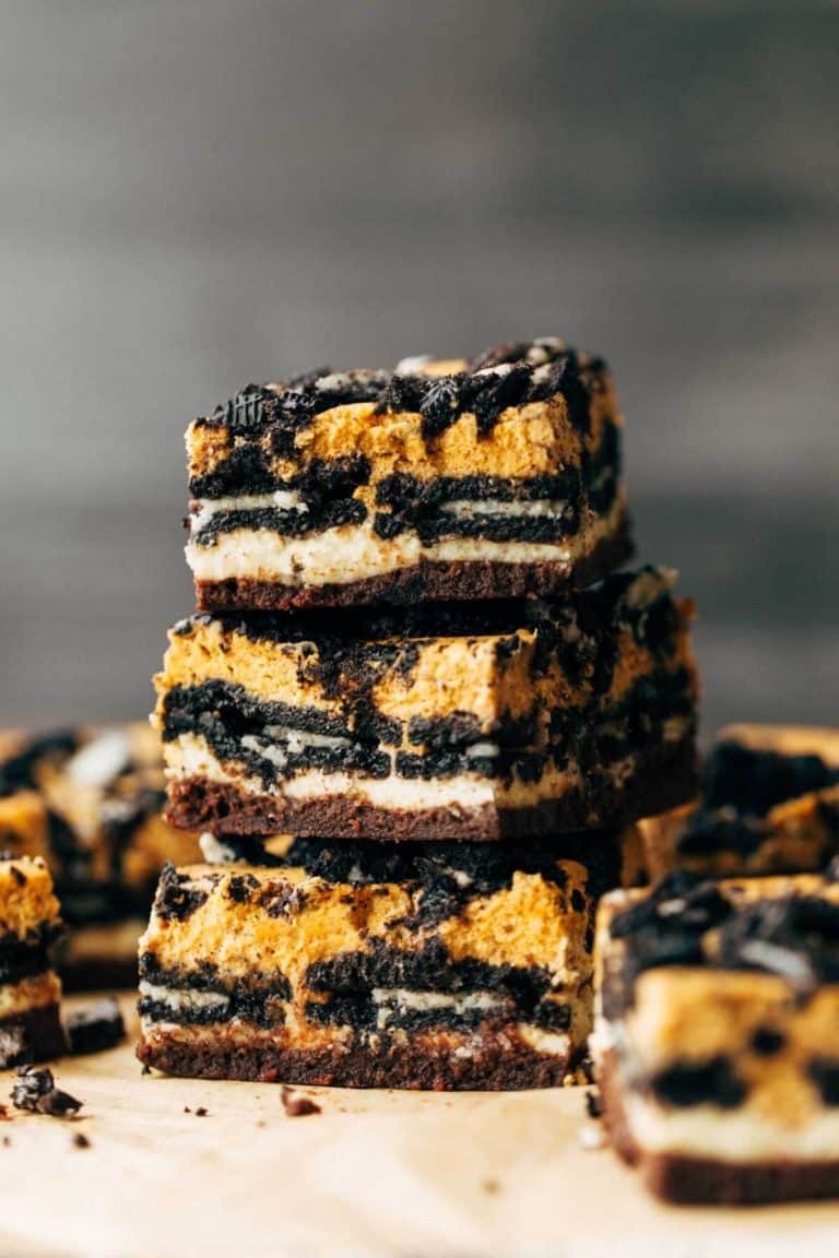 three pumpkin oreo cheesecake bars stacked on top of each other