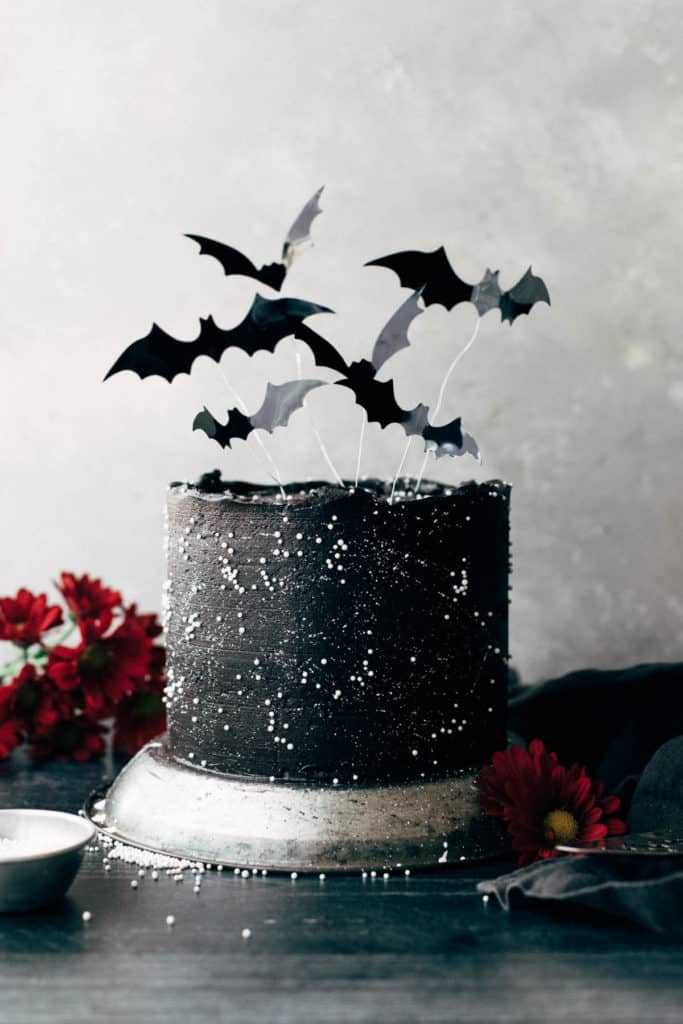 a completed black velvet cake decorated with flying bats on top