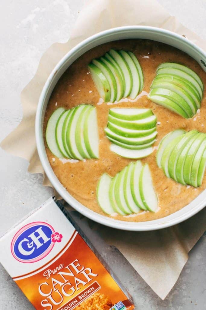 slices of apples placed on top of apple cake batter