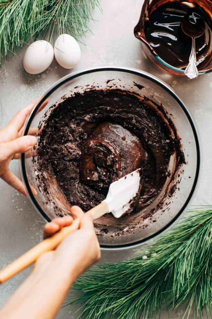 folding dry ingredients into a bowl of brownie batter