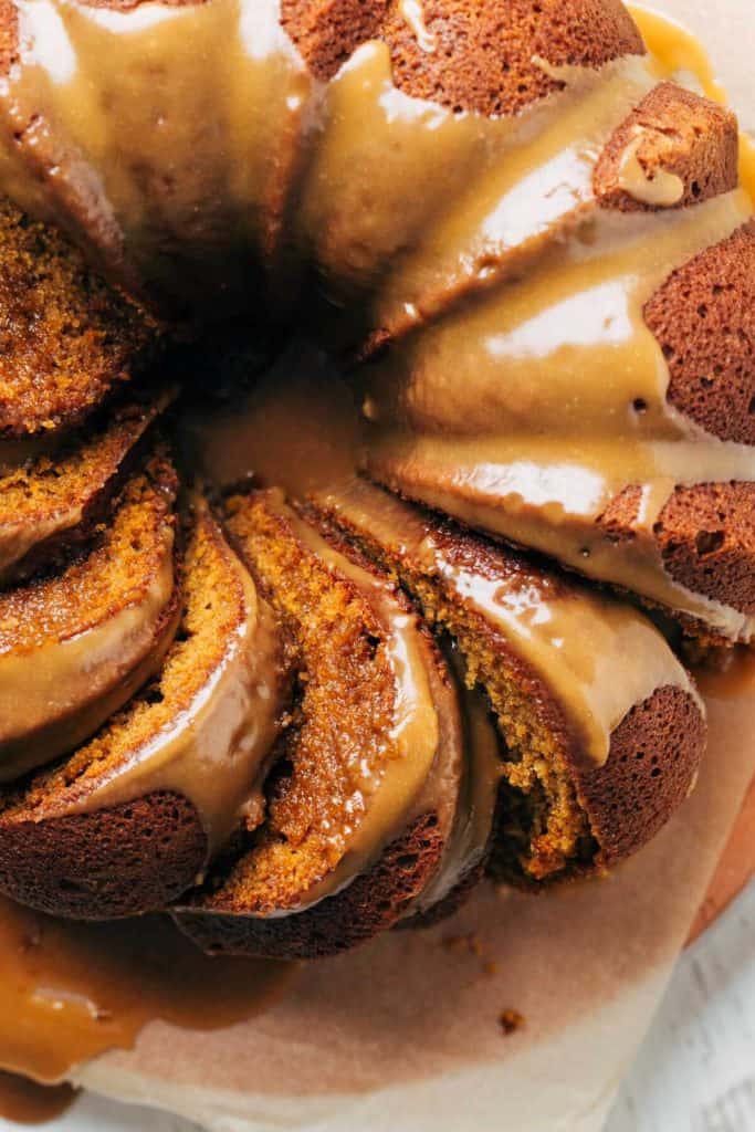 close up on the top of a pumpkin bundt cake with slices laying in their sides