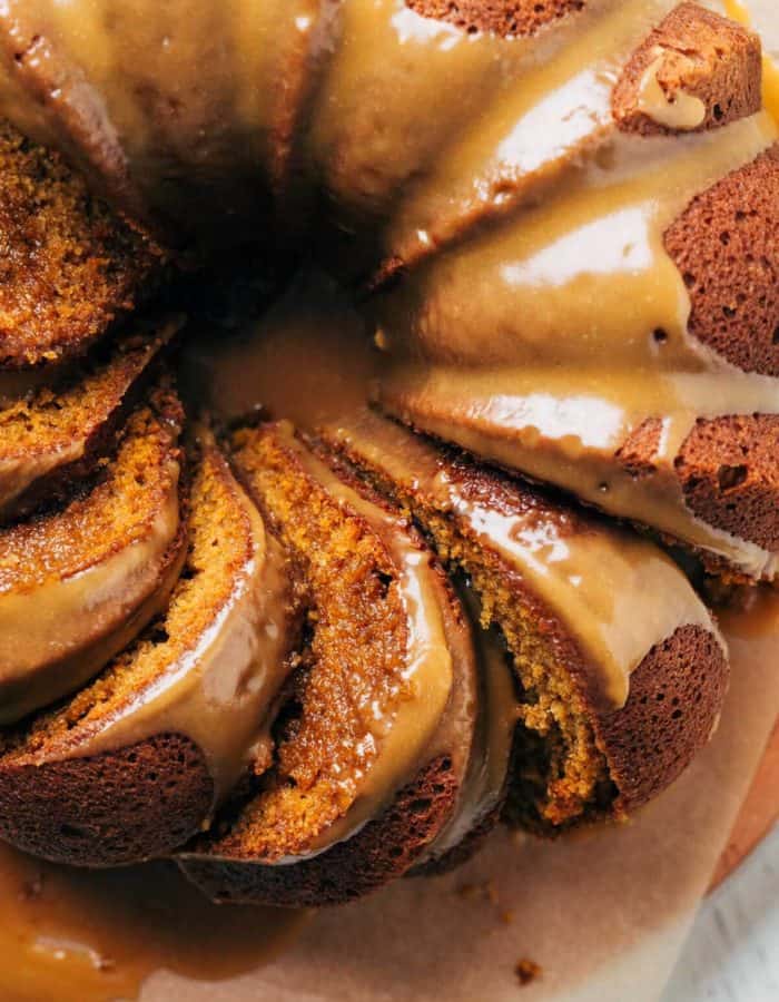 close up on the top of a pumpkin bundt cake with slices laying in their sides