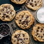 chocolate chip cookies scattered across a sheet of parchment paper