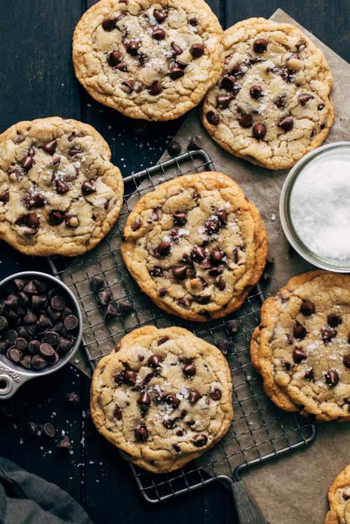 chocolate chip cookies scattered across a sheet of parchment paper