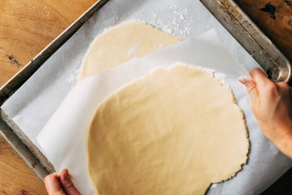 stacking a sheet of rolled out cookie dough on top of another