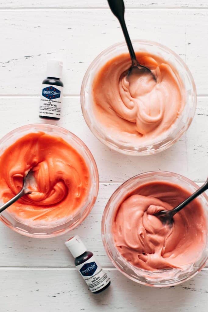 bowls of colored cream cheese frosting